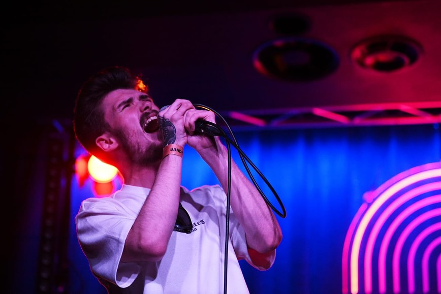 Gaz Kelly singing live under stage lights